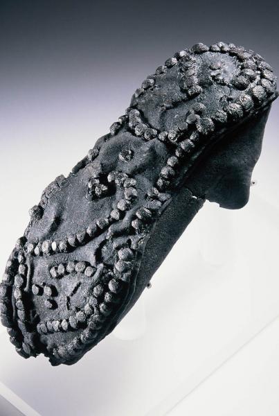 A photograph of the sole of a shoe with metal tacks forming a decorative pattern